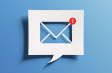 An image of message inbox icon cut out of paper with a red message notification on a blue background