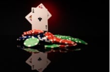 pile of poker chips with a Jack and an Ace card sticking out at the tops of the pile
