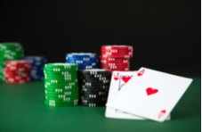 Ace and Jack of hearts on a poker table with piles of poker chips