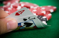 A close-up photo of a hand holding a natural blackjack – an ace and a black Jack of spades