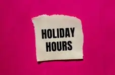 An image of a torn white paper note with "Holiday Hours" text on a bright pink background
