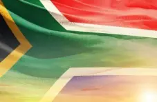 A full-frame photo of the South African flag backlit by sunlight