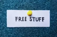 An illustration of a paper note pinned with a yellow tack reading “Free Stuff” on a textured blue glitter background