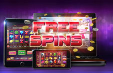 An illustration of a laptop, smartphone and tablet displaying a slots game with FREE SPINS in bold red on a purple background