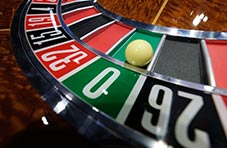 A realistic close-up 3D illustration of a single zero roulette wheel with a white ball on the 0
