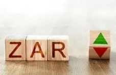 A photo of wooden blocks spelling “ZAR” next to a separate block showing green and red up and down arrows on a wooden surface