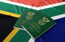A photo of the South African flag with two green ID books on top of it