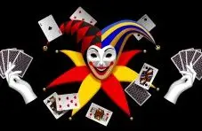 An illustration of a smiling joker mask, jester hats, flying playing cards and two hands holding card fans isolated on black 