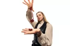A photo of a female croupier isolated on a white background juggling red and white casino chips