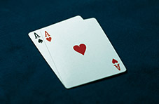 An image of a pair of aces on a dark blue felt table