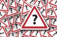 An illustration of overlapping triangular red and white road signs with black question marks on