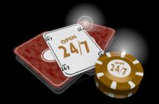 A spliced deck of cards with an up card and a stack of casino chips both saying 'open 24/7' in gold on a dark background