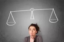 A photo of a woman standing in front of a blackboard with weight scales in white chalk inscribed above her head