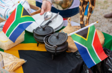 An image of potjiekos on a table with the South African flag 