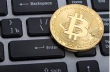 a bitcoin sitting on a computer keyboard