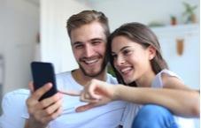 young couple playing on their mobile phone together