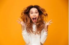 very excited woman screaming with joy with a yellow background