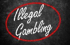 a black board with ‘Illegal Gambling’ inscribed in white on the board with a thick red line running through the words.