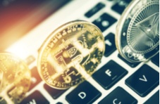 Transparent gold and silver crypto coins superimposed on a computer keyboard