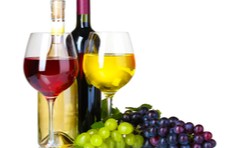 grapes and two bottles of red and white wine and wine in glasses