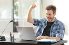 happy winner playing on his laptop