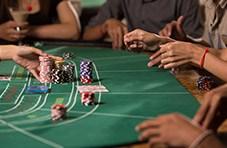 a crowd of players around a baccarat table