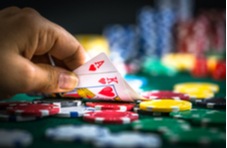 man's hand showing a King and Ace on a pile of poker chips