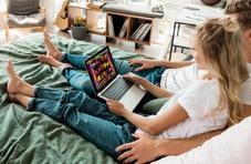 A couple in bed playing a casino game