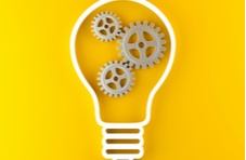 image of a light bulb on a bright yellow background with gears in the bulb