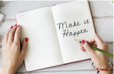 woman writing "Make it Happen" in her diary