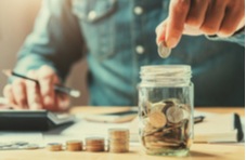 a man counting his change into a jar