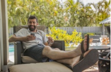 a man relaxing by the pool with Springbok casino on his phone screen