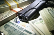 pile of money with gun and bullets