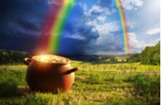 a pot of gold coins at the end of a rainbow across a field