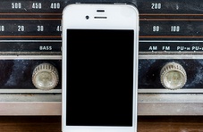 old fashioned radio with a smartphone leaning against it