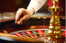 roulette wheel with a hand dropping a ball onto the wheel