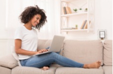 woman sitting on her sofa with her laptop