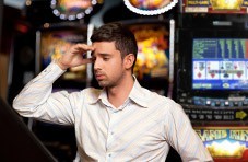 A video poker player at a land based casino looking confused.