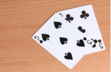 two playing cards showing fives