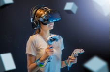 woman wearing virtual reality headset and holding gaming controls in her hands signifying the future of gaming at Springbok